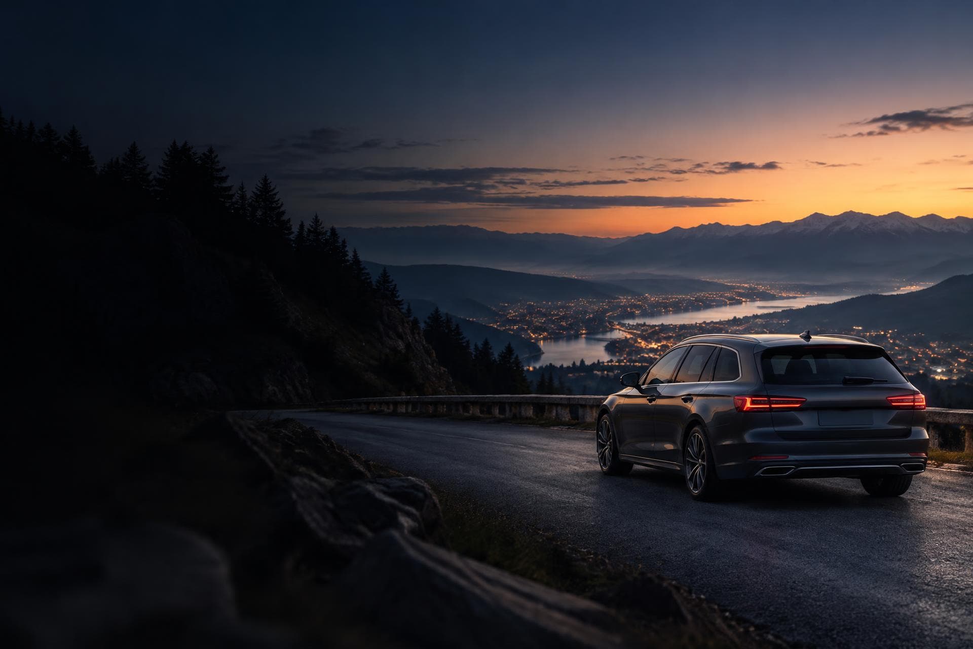Automobil pe un drum de munte, cu orașul luminat în depărtare